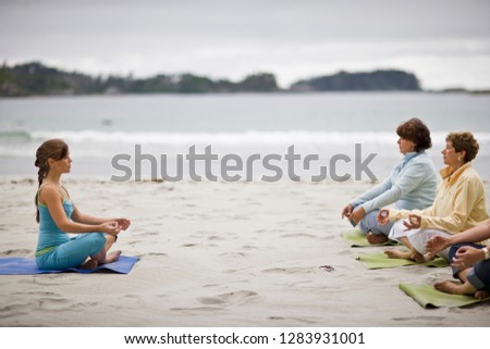 Young adult girl practicing yoga with her mature grandmother and mid-adult mother.