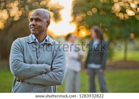 Bald man stands in park