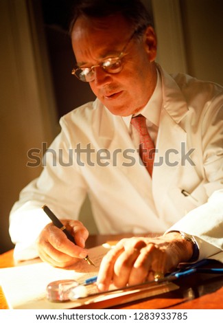 Portrait of a doctor writing on a notepad.