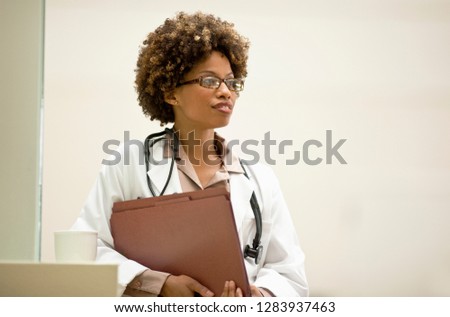 Portrait of female doctor holding patient files.