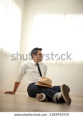 Young man with fedora hat sitting on the floor