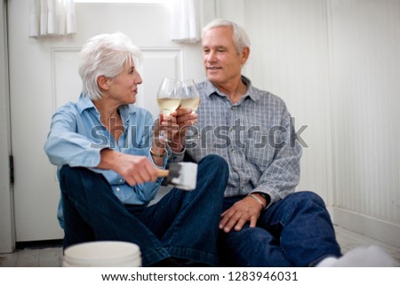 Couple toasting each other as they celebrate buying a house together.