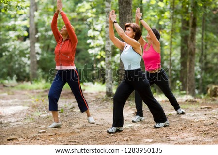 Middle aged women doing yoga in forest