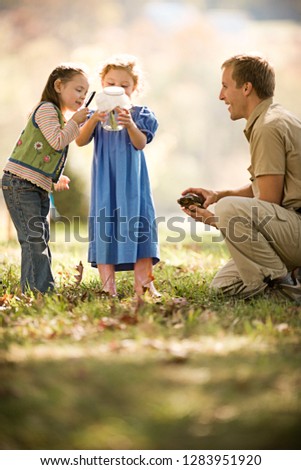 Ranger showing kids bugs in a jar and a tortoise