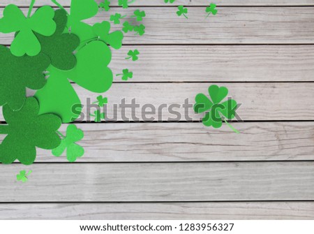 fortune, luck and st patricks day concept - green paper shamrocks on grey wooden boards background