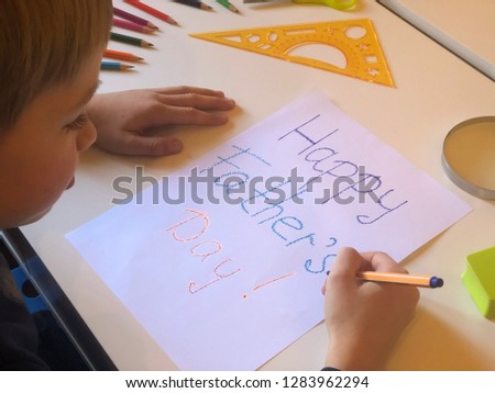 Little boy is drawing a greeting card for his father. Happy Father's Day. Concept