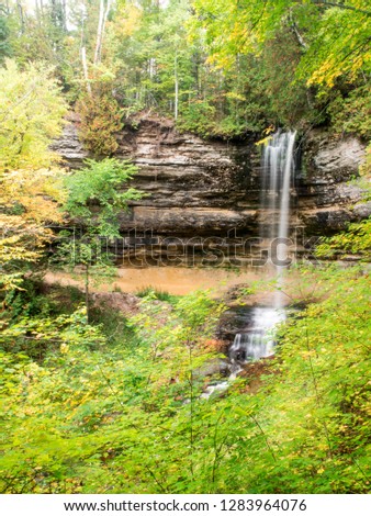 USA, Michigan, Upper Peninsula. Munising Falls framed by hardwood forest in autumn, Pictured Rocks National Lakeshore, Upper Peninsula of Michigan.