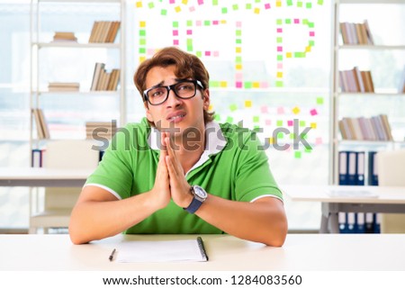 Student struggling at the exam in classroom