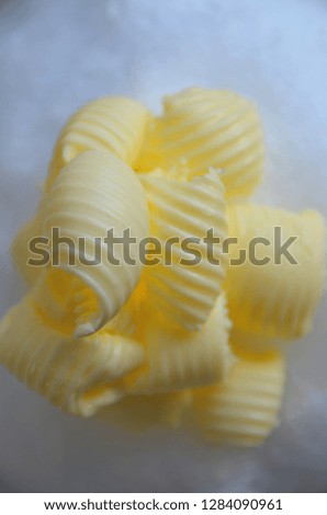 Rolls of butter. Butter curls. Butter is used for cooking and baking and it adds a tasty flavor to the food. Picture is ideal for advertising dairy products,