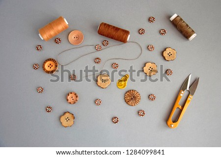 accessories for sewing and needlework: buttons, scissors, needle with thread, set of reel of thread, top view Royalty-Free Stock Photo #1284099841