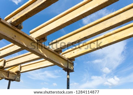 Formwork construction concept. Low angle top view photo of incomplete family building with wooden beam under blue peaceful sky