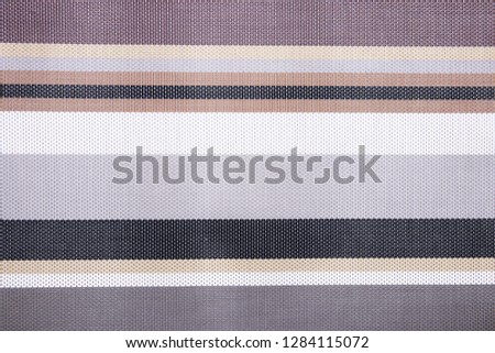 Striped background. Top view of details of colorful horizontal striped background texture with seamless pattern on plastic tissue. Macro.