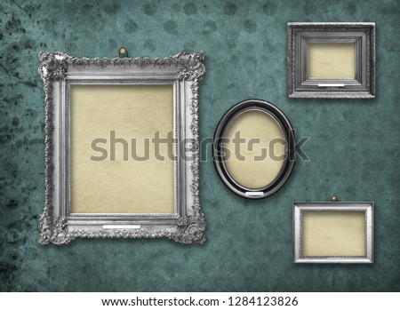 Set of wooden vintage silver baroque frames for museum exhibition on old, worn turquoise wall