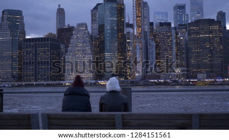 Two young woman enjoy a wonderful evening at the Manhattan skyline in New York