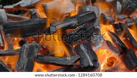 Glowing charcoal and flame in the barbecue grill