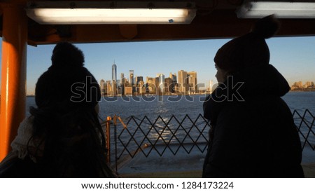 Two girls ride the Staten Island Ferry on a sunny day