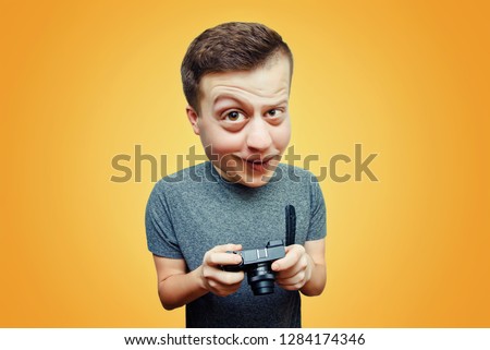 Portrait of a guy, funny caricature of a surprised man with a camera in his hands on a bright background.  Caricature of a photographer with a camera in the studio. Funny man with big head
