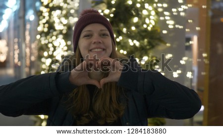 Young girl forms a heart with her hands