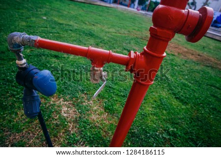 Bright red pipe on the grass