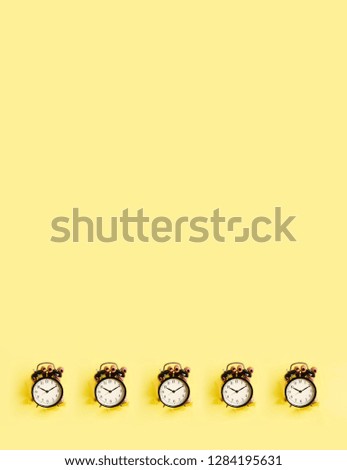 Pattern of hands holding black alarm clock through hole in yellow paper background. Wake up alert concept. Morning routine. Minimalist style design. Banner with copy space.