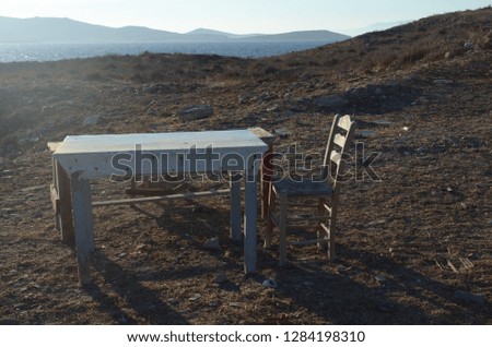 Abandoned and old wooden tables and chair on a seaside cliff
