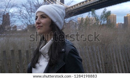 Young woman walks along Hudson River at Brooklyn Bridge New York