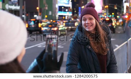 Two girls in New York take photos at Times Square
