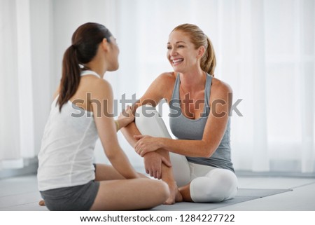 Smiling young women taking a break from a yoga class.