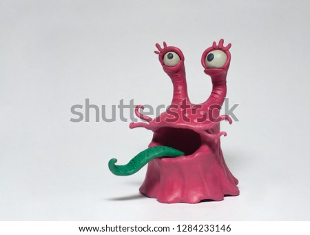Funny pink monster bacterium with a long tongue. Plasticine character on a white background Royalty-Free Stock Photo #1284233146