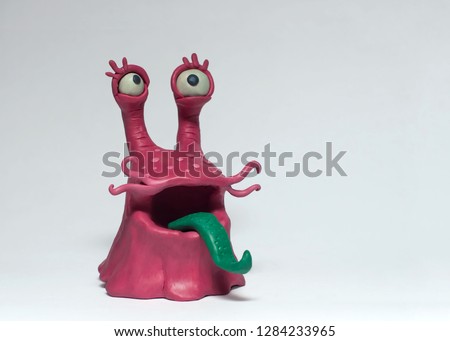 Funny pink monster bacterium with a long tongue. Plasticine character on a white background Royalty-Free Stock Photo #1284233965
