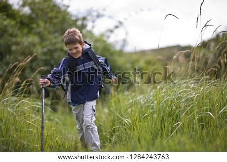 Happy boy hiking through tall grass