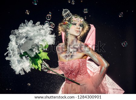 Girl, spring fairy with a dandelion in her hands. Beautiful makeup, spring.