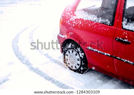 Tire track of red car in snow. Copy space for text on white. Wheel on Slippery road. Driving safe on winter blizzard