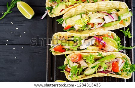 Mexican tacos with chicken meat, avocado, tomato, cucumber and red onion. Healthy tortilla. Wrap food. Taco. Top view