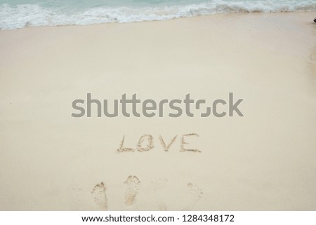 Word "Love" writing on the sand