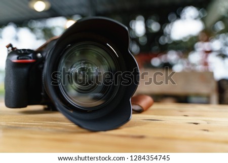 Modern camera lens for professional photography on wooden desk