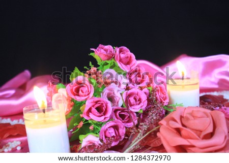 Photoshoot of beautiful bouquet roses with candle burning. Background Valentine day