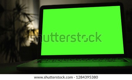 Close-up shot , Laptop with green screen indoors for replacement with blur background 