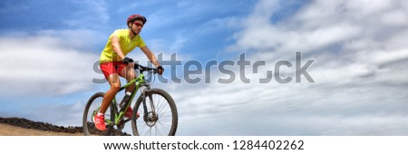 Sport athlete fitness training biking on mountain MTB bike landscape banner panorama. Copy space on blue sky background. Man cyclist riding bicycle outdoors.
