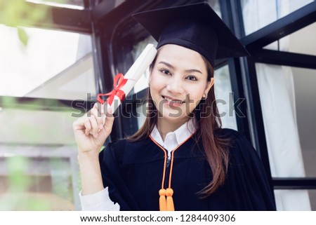 Asian woman happy graduate showing certificated in hand with in the garden.color tone