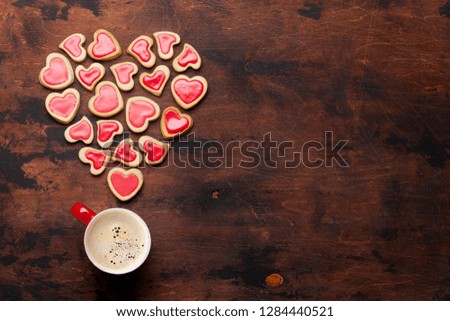 Valentine's day greeting card with coffee cup and heart shaped cookies on wooden background. Top view with space for your greetings. Flat lay