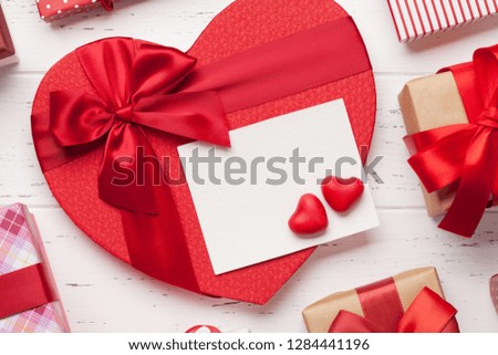 Valentine's day greeting card with heart gift boxes on wooden background. Top view with space for your greetings. Flat lay