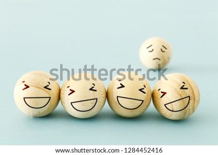 concept of bullying , discrimination. group of laughing emoticon faces and one alone look sad and depressed. Royalty-Free Stock Photo #1284452416