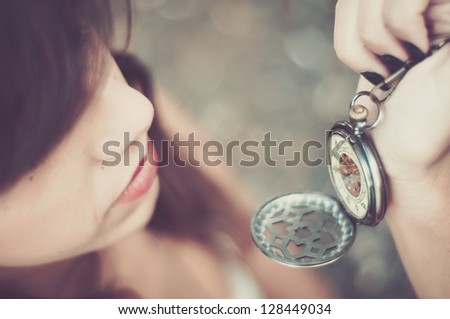 young woman checking time on a pocket watch Royalty-Free Stock Photo #128449034