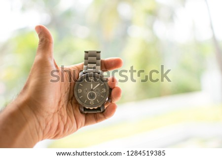 Man holding watch in his hand