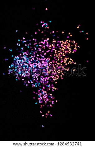 Multicolor bokeh lights, tiny hearts on a black background, top view, carnival, night party invitation or festive background, starry night sky