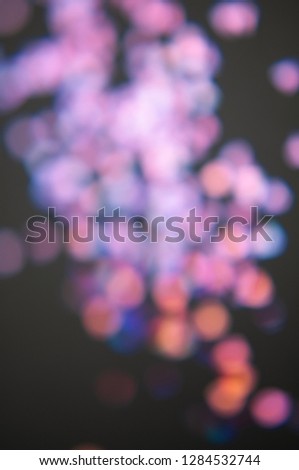 Multicolor bokeh lights on a black background, top view, carnival, night party invitation or festive background, starry night sky
