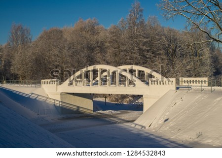 Latvia. Pedistrian and auto bridge throught the river Vircava in Mezciems, Jelgava. Winter time.