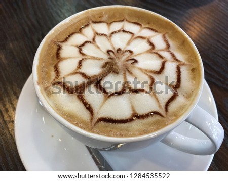 A cup art of cappuccino coffee foam art floating on top. Royalty high-quality free stock photo image a cup of latte art and cappuccino with leaf and flowers shape pattern made from milk surface