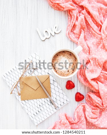 cup of coffee with chocolate candies, roses and envelope 